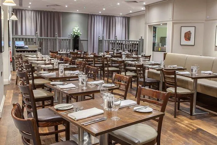 Laid dining tables with dark wooden ladder-back chairs